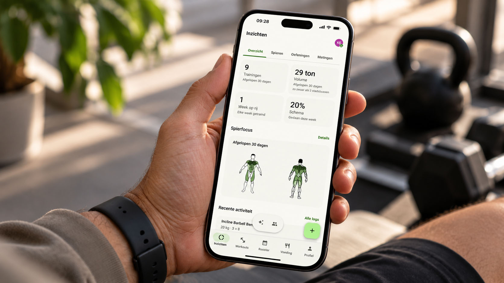 Hand met een telefoon waarop een fitness-app met trainingsinzichten draait