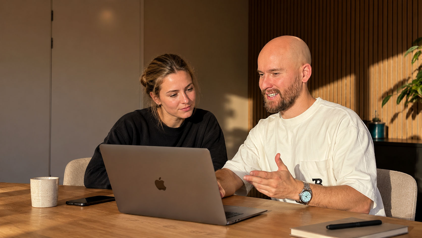 Kenny bespreekt met een klant een website op de laptop
